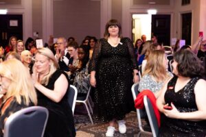 Sooz Young receiving applause while walking through the audience at the Digital Women Awards 2025 ceremony.