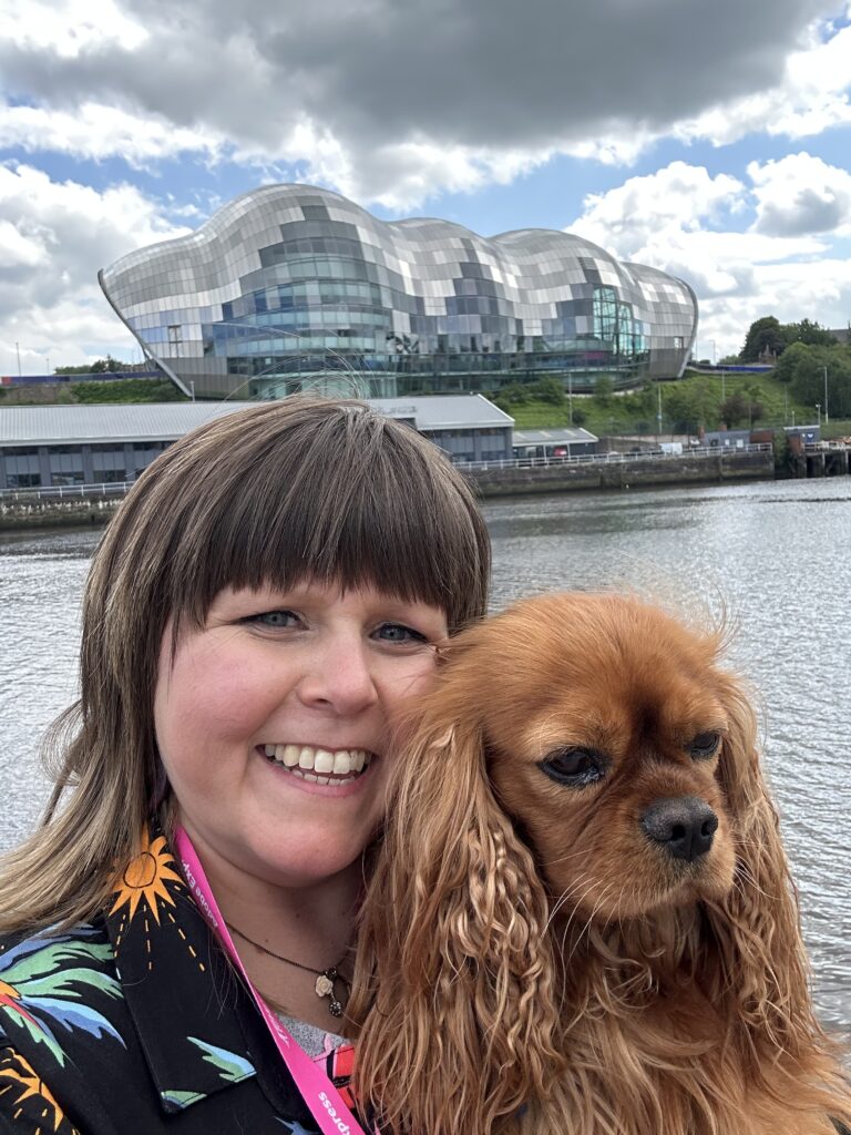 “Sooz Young with her ruby Cavalier King Charles spaniel, Disco. Beyond her role as founder of Technology Coaching and digital skills leader, Sooz is a creative at heart with a degree in Applied Music, a love of culture, and a passion for storytelling. She believes technology should never replace human connection — only amplify it.